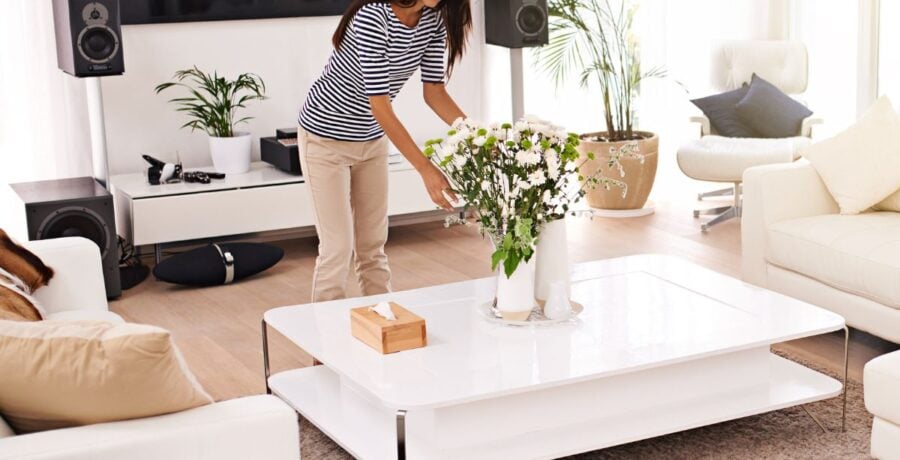 Lady Making Her Home Look Lovely By Arranging Flowers In A Vase In Her Lounge